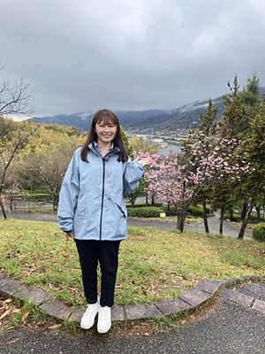 桜を背景に西上さん