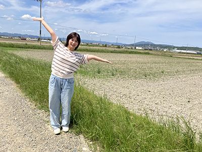 田畑を背景に稲富さん